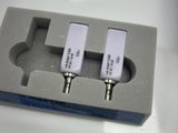 three microphones in a box on a white table