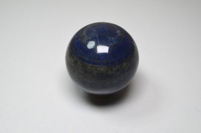 un gros plan d'une bille bleue posée sur une surface blanche