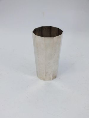 a close up of a silver cup on a white surface