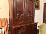 une armoire en bois et une chaise dans une pièce