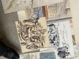 a person standing in front of a bunch of drawings on the floor