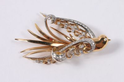 a gold and diamond brooch with a bird on it