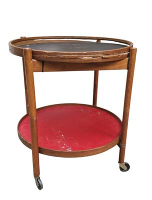 une petite table en bois sur laquelle est posé un plateau rouge