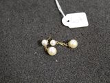 a close up of a pair of earrings on a black surface