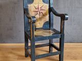 une vieille chaise en bois posée sur un parquet, près d'un mur