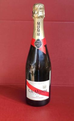 une bouteille de champagne posée sur une table rouge, avec un fond rouge