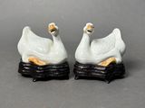 two figurines of swans sitting on top of each other