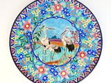 une assiette sur laquelle sont représentés deux oiseaux, posée sur une table