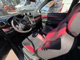 un siège rouge et noir dans une voiture équipée d'un volant