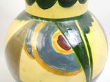 un vase jaune orné d'un motif vert et jaune