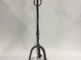 an old iron floor lamp with a candle on it