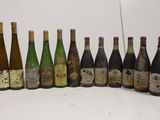 several bottles of wine are lined up in a row on a white surface