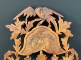 a wooden clock with a bird and flowers on it