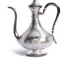 cafetière plaquée argent avec une poignée et une anse, sur fond blanc