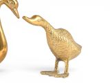 a gold duck and a golden duck standing next to each other