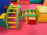 brightly colored children ' s play area with ladders, blocks, and other toys