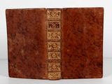 un vieux livre à la couverture brune posé sur une table
