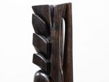 sculptures made of wood sit on a white pedestal against a white background