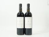 deux bouteilles de vin posées l'une à côté de l'autre sur une surface blanche