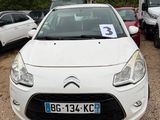 a small white car parked in a lot with other cars