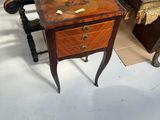 a small table with a drawer on it in the middle of a room