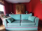 un canapé bleu dans un salon aux murs rouges