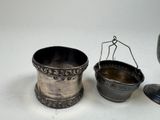 a silver cup and spoon sitting next to each other on a table