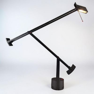 une image représentant une lampe de bureau avec un pied noir et une ampoule rouge