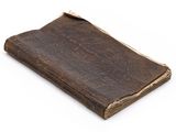 an old book with a brown leather cover on a white background