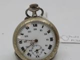 a small gold pocket watch with roman numerals on it