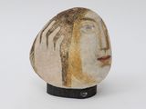 a rock with a face on it on a white surface