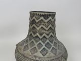a black and white vase sitting on a white surface