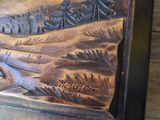 a picture of a wooden carving of a mountain scene