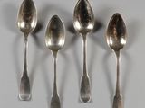 cinq cuillères sont alignées en rang sur une table