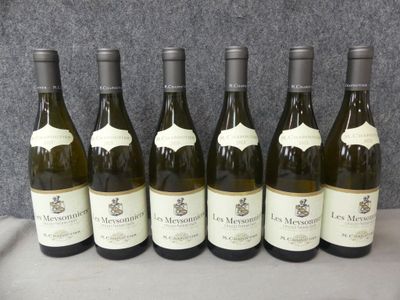 six bouteilles de vin sont alignées sur une table