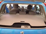 the back of a blue car with its trunk open in a garage