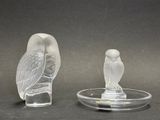 deux figurines en verre représentant des chouettes posées sur un plateau en verre