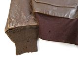 une paire de gants et une veste posés sur une surface blanche