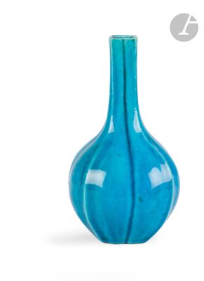 un vase bleu posé sur une surface blanche