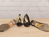 three pairs of black and white shoes sitting on top of a wooden table