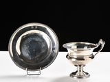 silver plate and bowl on a white table with a black background