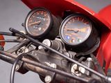 a close up of a red motorcycle with gauges on it ' s handlebars