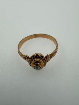 a close up of a gold ring with a stone in the center
