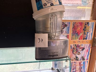 un mixeur posé sur une étagère en verre devant une fenêtre