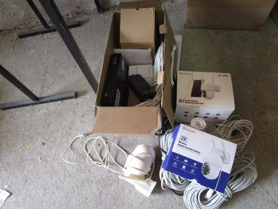 une boîte contenant des composants électroniques et une boîte de câbles posées par terre