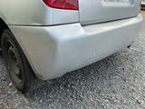 a car that is parked in a lot with gravel on the ground