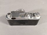 a small silver camera sitting on a white surface