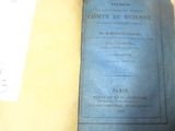 un livre bleu posé sur une table, à côté d'une tasse de café