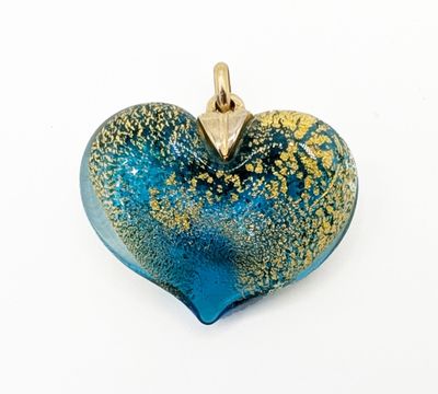a blue and gold heart shaped pendant on a white surface