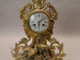 a gold clock sitting on top of a table